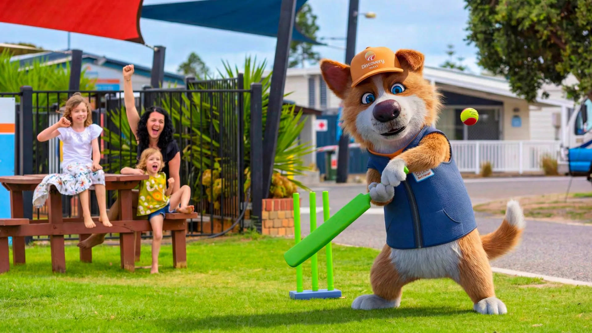 Bruce the Bark Manager playing backyard cricket with a family at a Discovery Parks holiday park