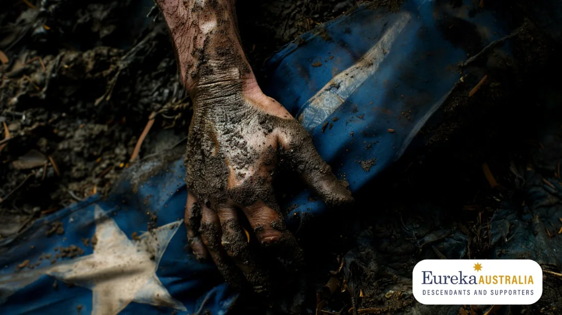 A mud-covered hand resting on the Southern Cross flag on the ground