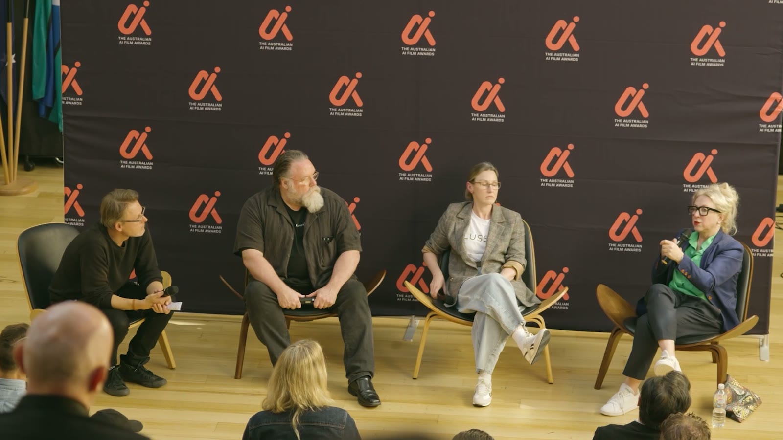 Four panellists in conversation in front of The Australian AI Film Awards backdrop
